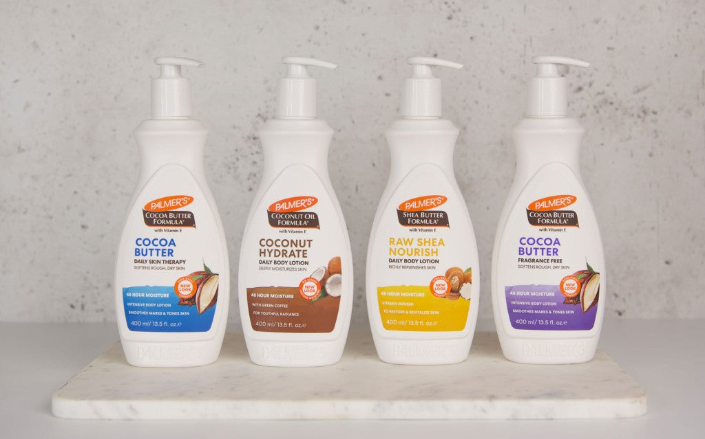 Palmer's Coconut Oil Formula and Cocoa Butter Formula products with natural skincare ingredients on a wooden tray