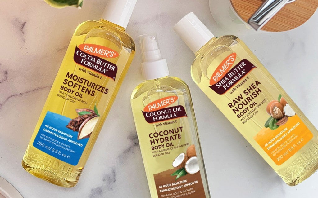 Palmer's body oils laying on white marble bathroom counter