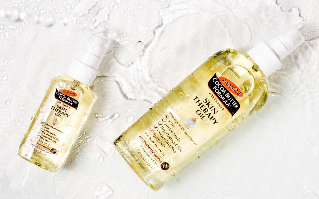 Palmer's Skin Therapy Oil and Skin Therapy Face Oil, the best face and body oils for dry skin, on top of books with planter in background 