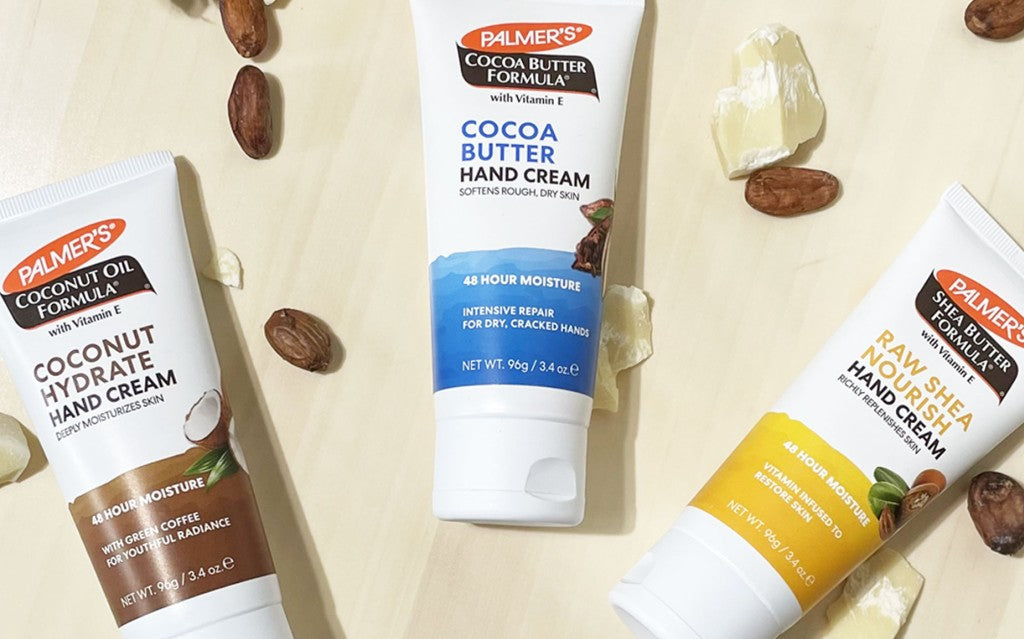 Palmer's Hand Cream collection for helping to heal super dry hands in the winter on a table with books