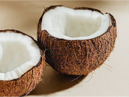 picture showns a coconut that has been split in half showing the white flesh