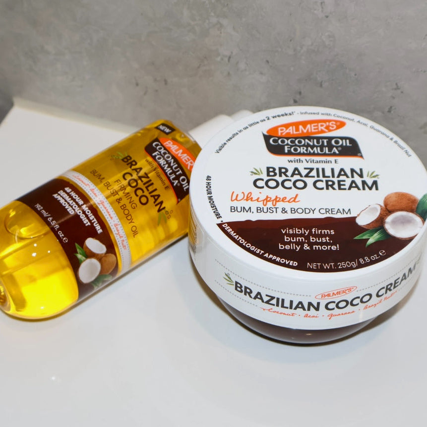 Palmer's Brazilian Coco Whipped Body Cream and Firming Oil shown scattered on a bathroom counter top