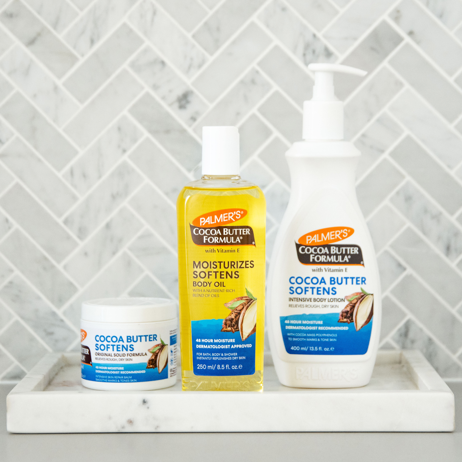 Palmer's Cocoa Butter Formula products on a marble surface with a tiled wall background