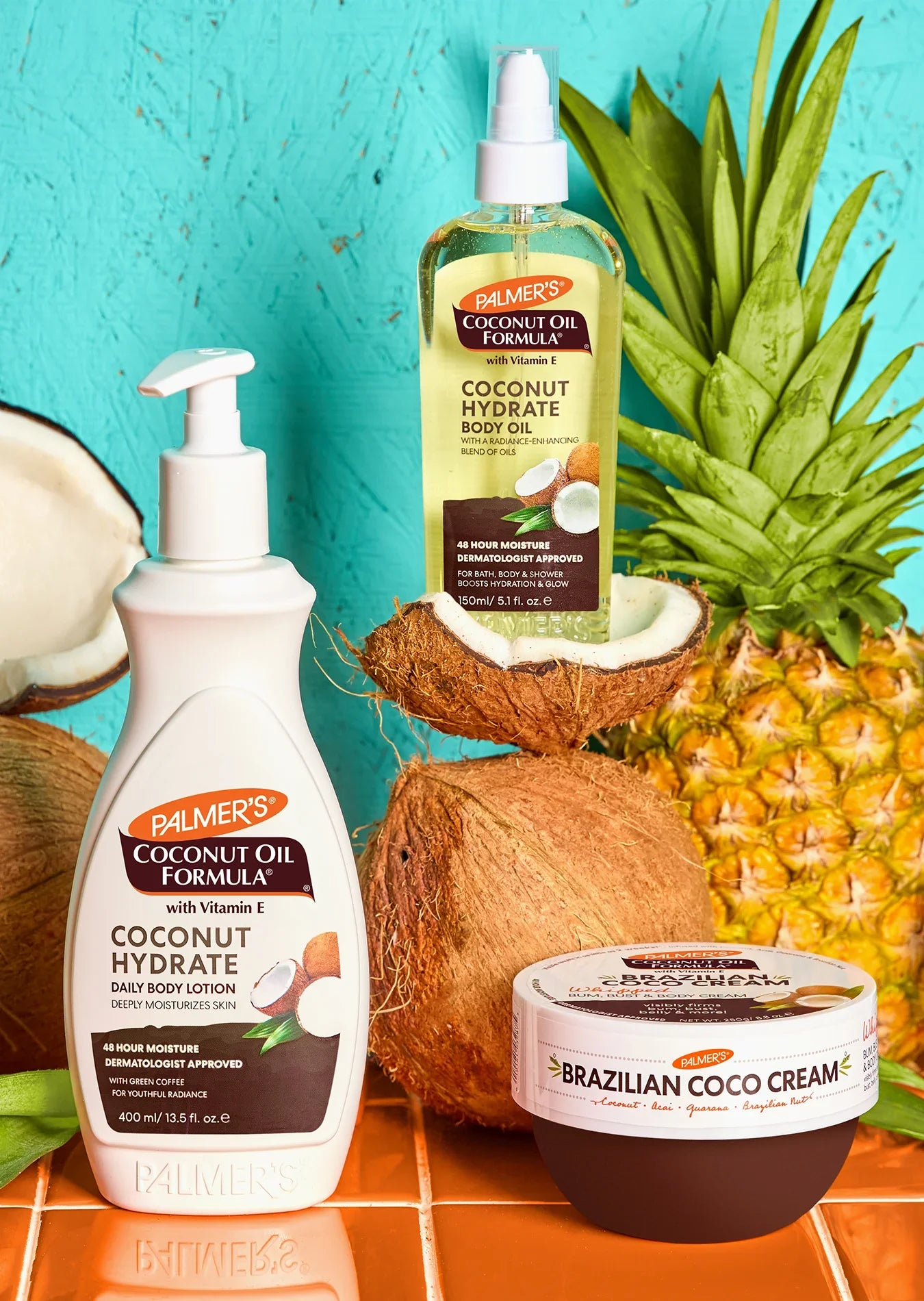 Palmer's Coconut Oil Formula range shown with pineapples and coconuts