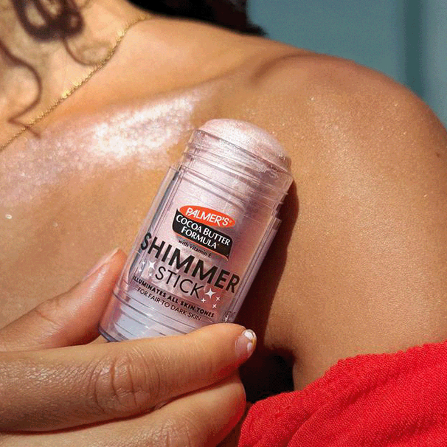 Palmer's Cocoa Butter Formula Shimmer Stick being applied to a person's shoulder.