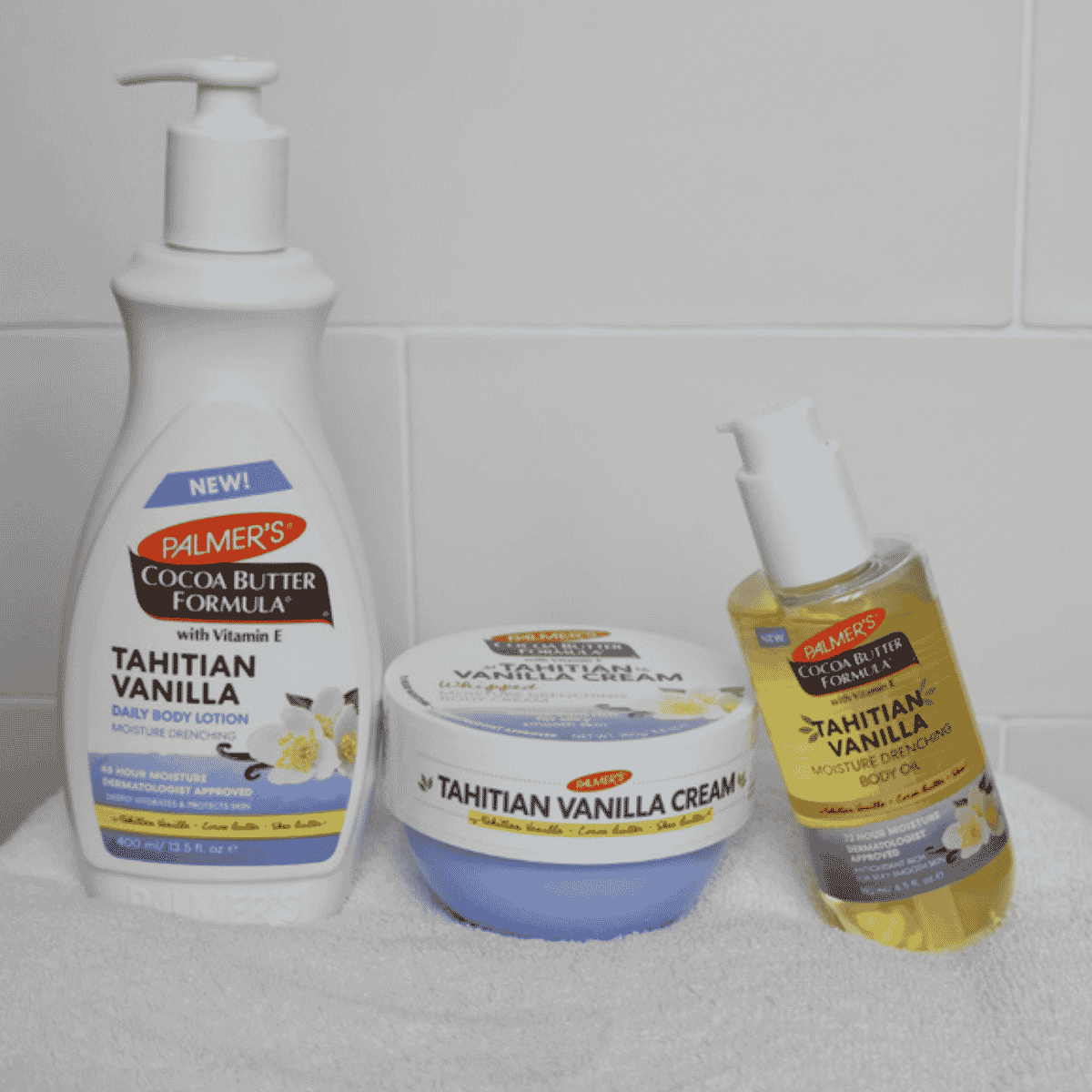 Palmer's Tahitian Vanilla skincare products including lotion, cream, and oil on a white surface.