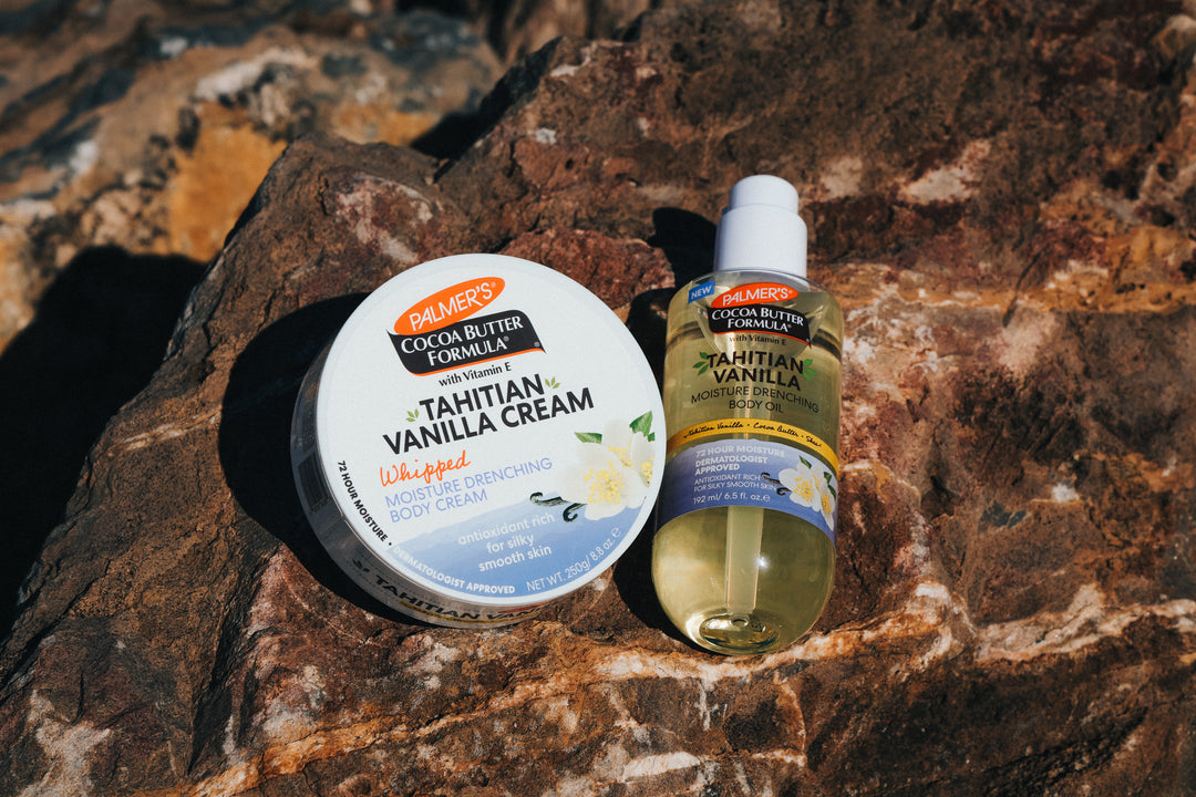 Palmer's Tahitian Vanilla Whipped Body Cream and Body Oil on a textured rock surface