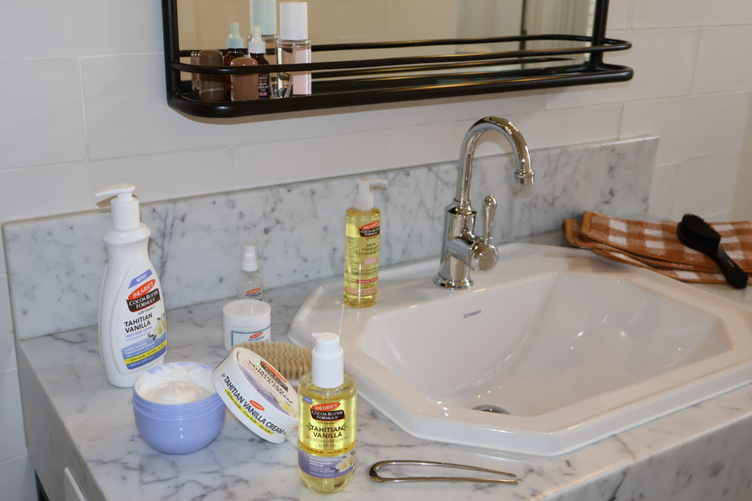 Bathroom sink with various Palmer's Body Care and Face products on a marble countertop
